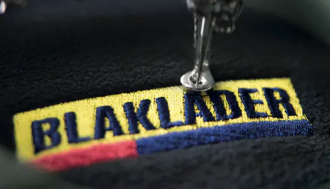 Blåkläder-Logo wird auf Arbeitskleidung gestickt